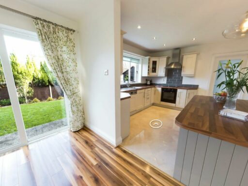 a kitchen with a view out to a grassy garden