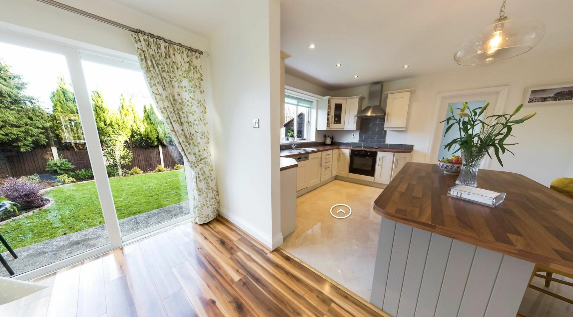 a kitchen with a view out to a grassy garden