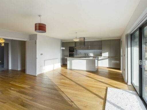 an empty kitchen with wooden floors