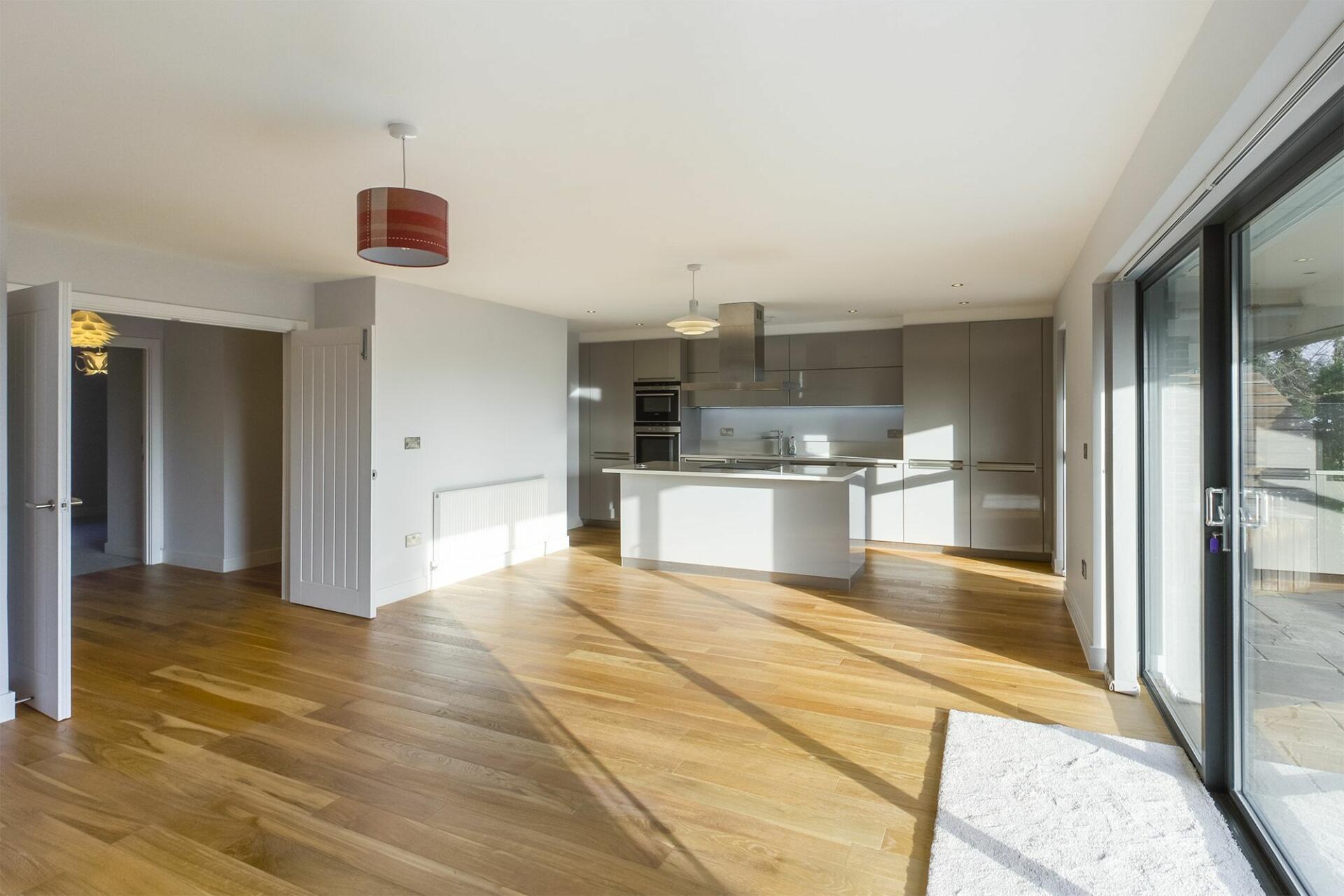 an empty kitchen with wooden floors
